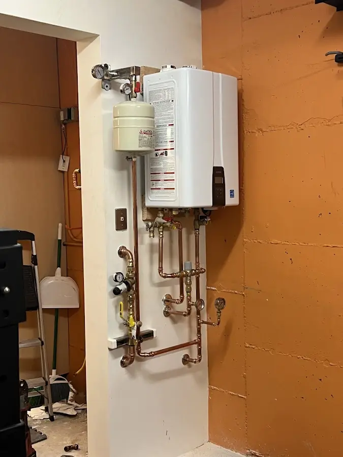 Plumbing technician inspecting water heater connections in Manitou Springs